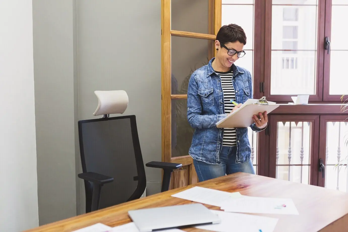 Happy businesswoman writing on some documents