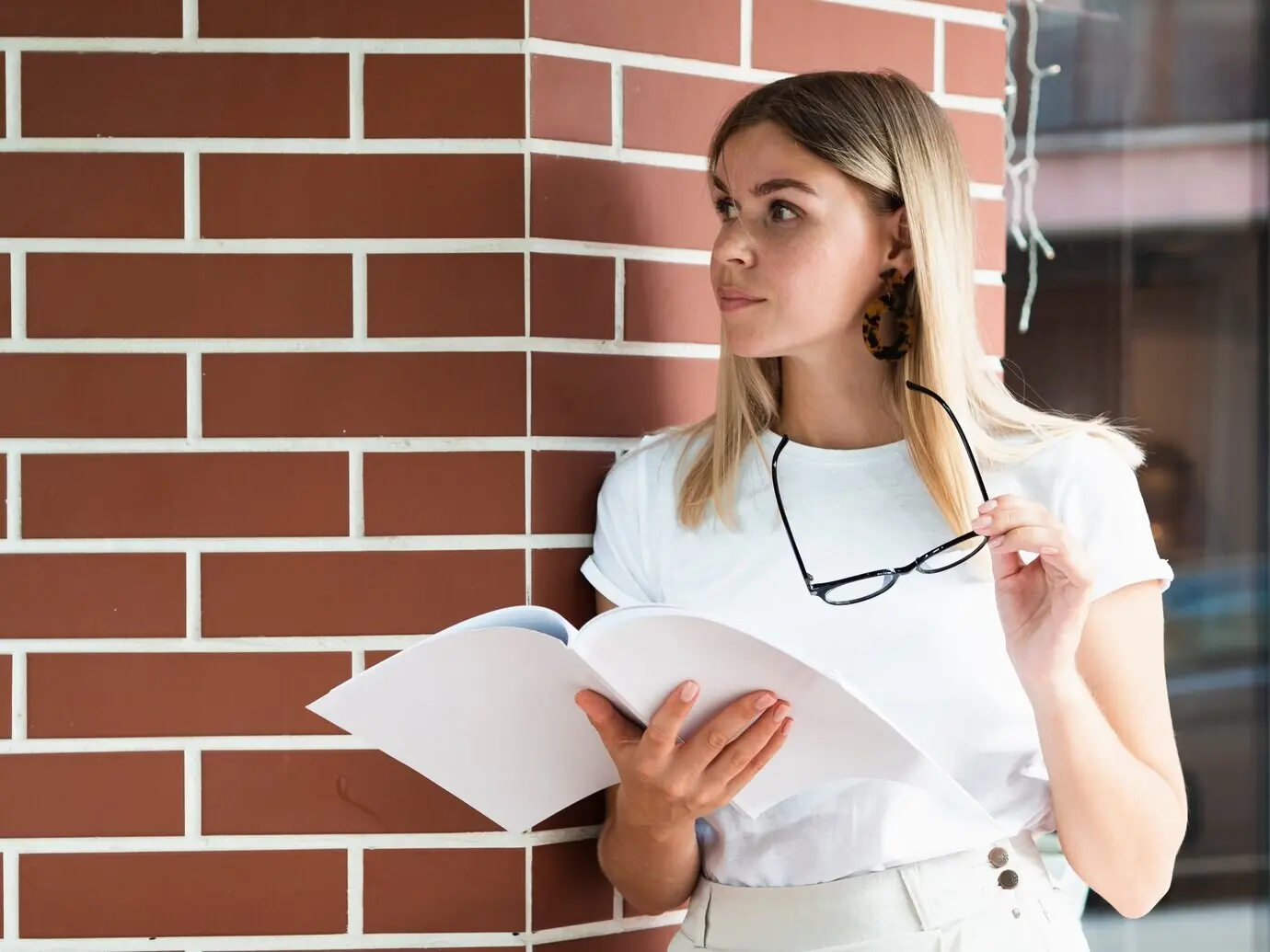 A woman holds a magazine mockup.